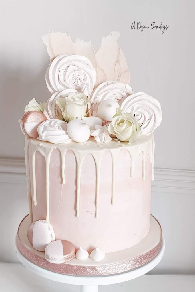 A pink and white chocolate drip birthday cake