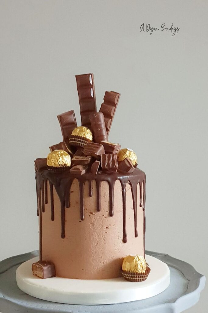 A chocolate overload chocolate drip birthday cake topped with lots of chocolate bars