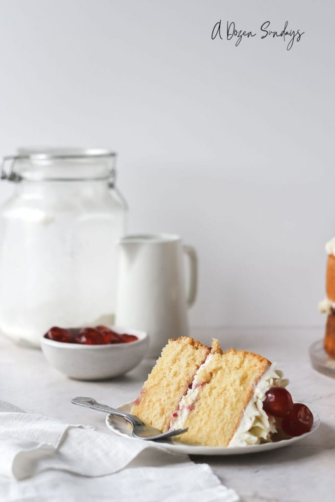 A slice of cake on a plate - easy Cherry Bakewell cake recipe from A Dozen Sundays