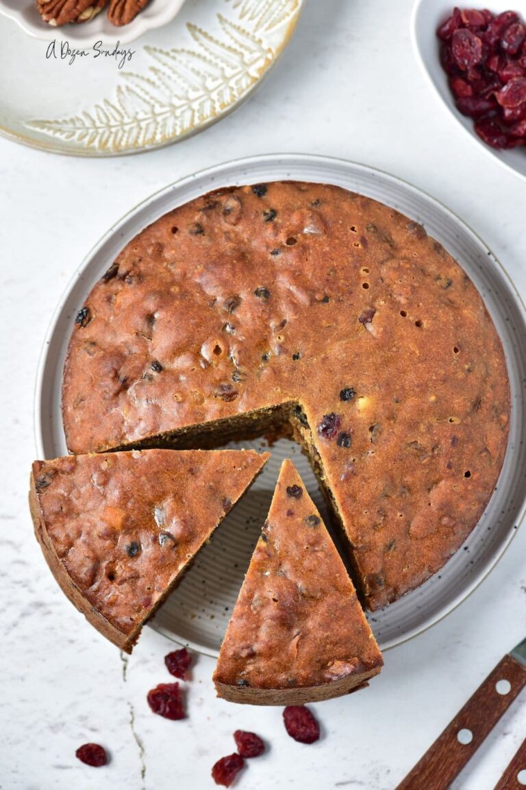 A top down view of a simple fruit cake with two slices cut out of it