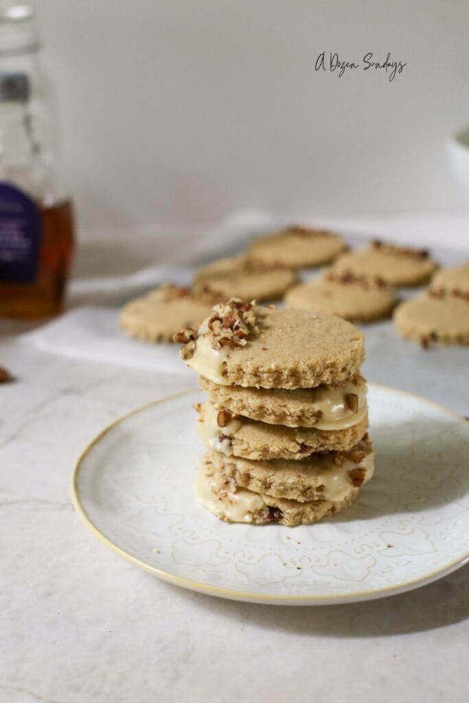 Pumpkin Spice Pecan Shortbread Cookies With Maple Glaze stacked up on a plate