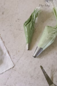 Two piping bags of green buttercream