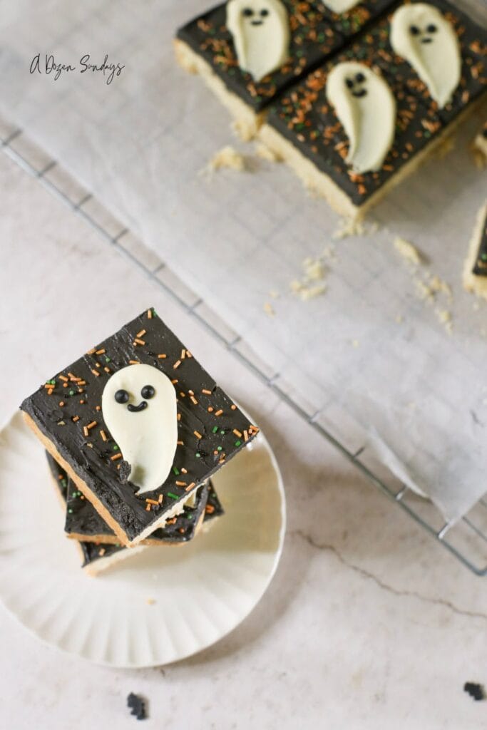 Halloween cookie bar, a shortbread cookie bar with black buttercream and a white chocolate ghost topper